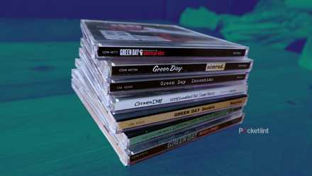 A stack of Green Day CDs on a coffee table
