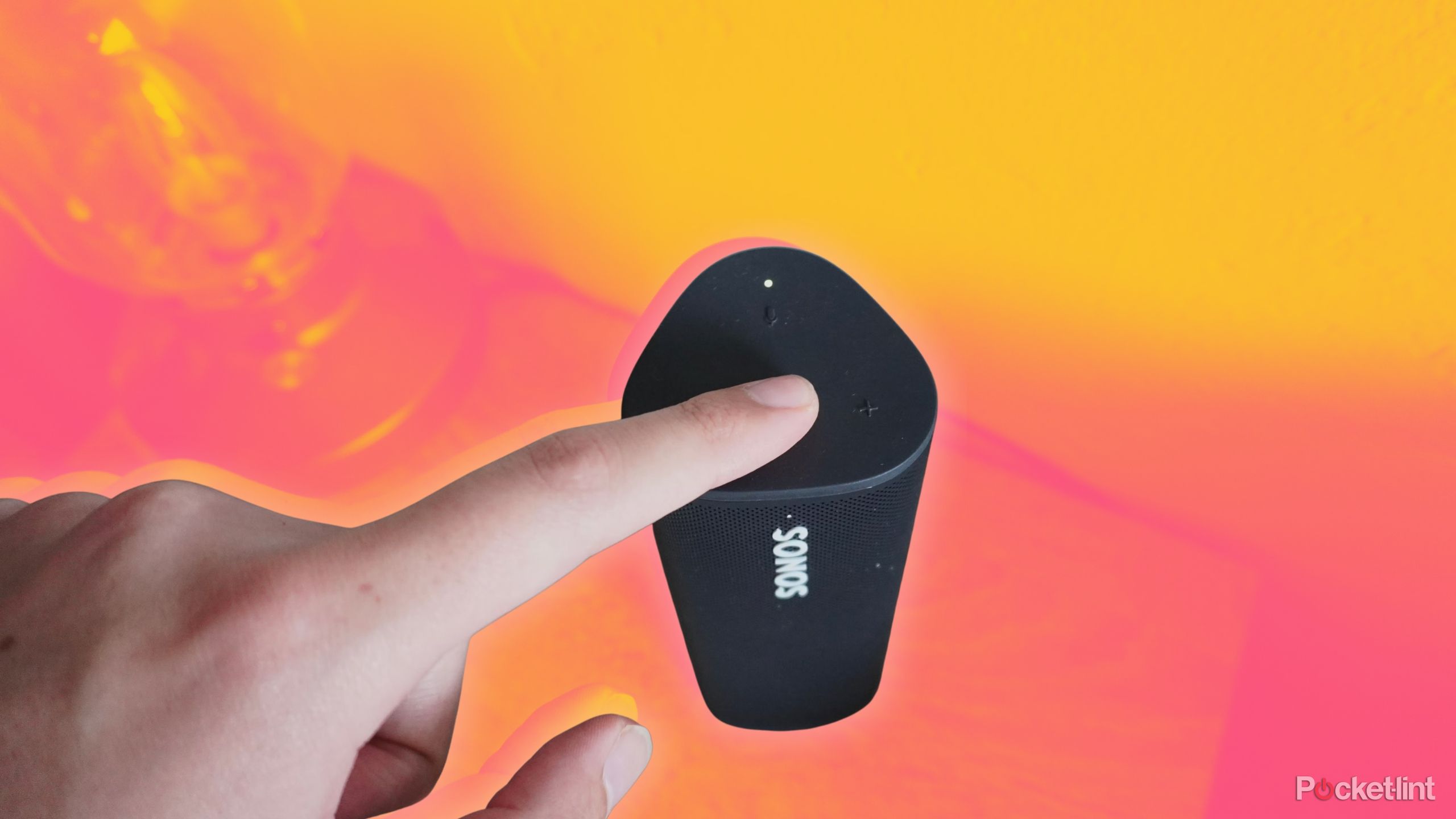 Pressing the Play/Pause button on a Sonos Roam speaker.