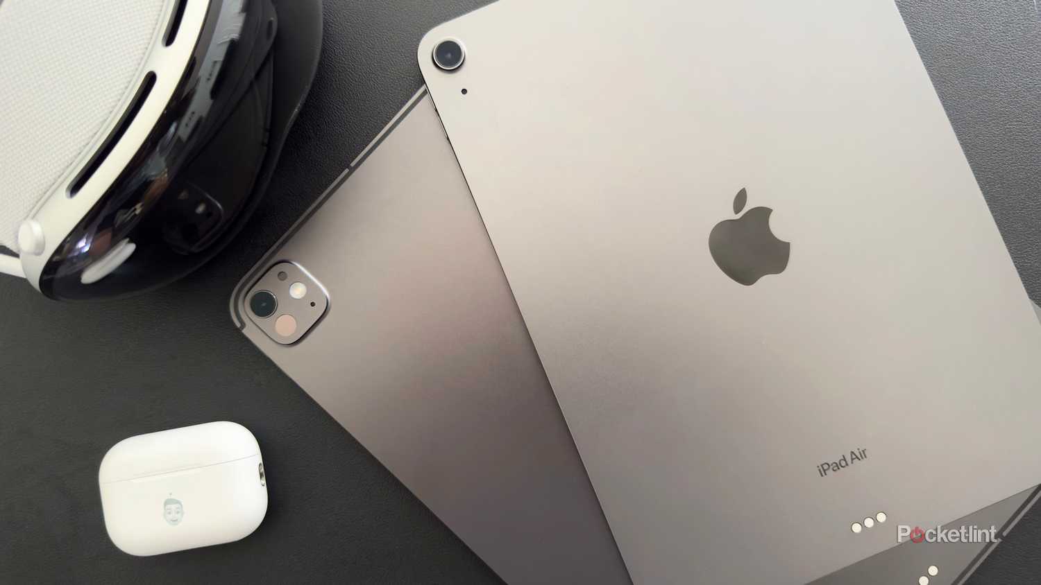 Two space grey iPads next to an Apple Vision Pro and AirPods Pro.