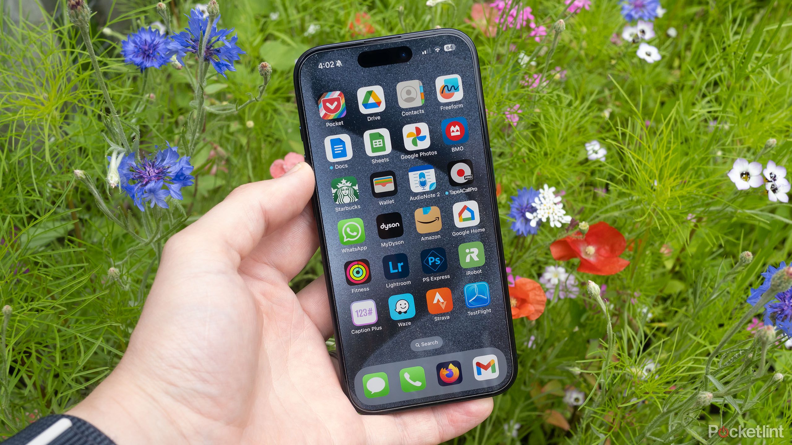 Apple's blue iPhone 15 Pro in front of flowers