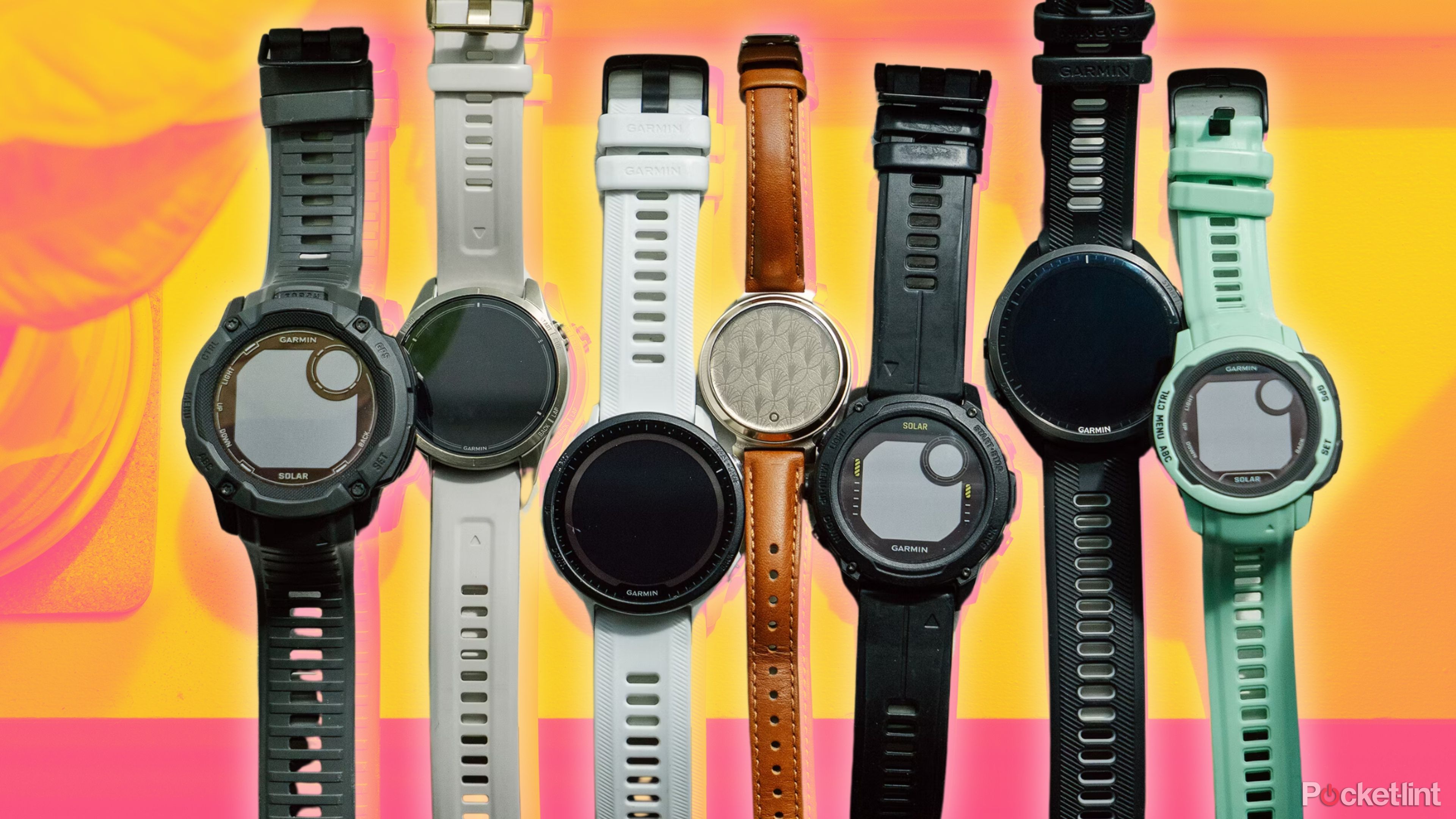 Seven Garmin watches lined up on a windowsill. 