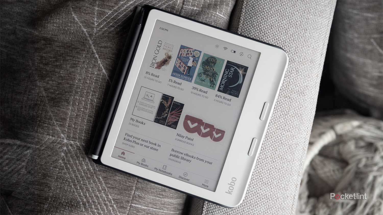 The Kobo Libra Colour sits on a gray couch.