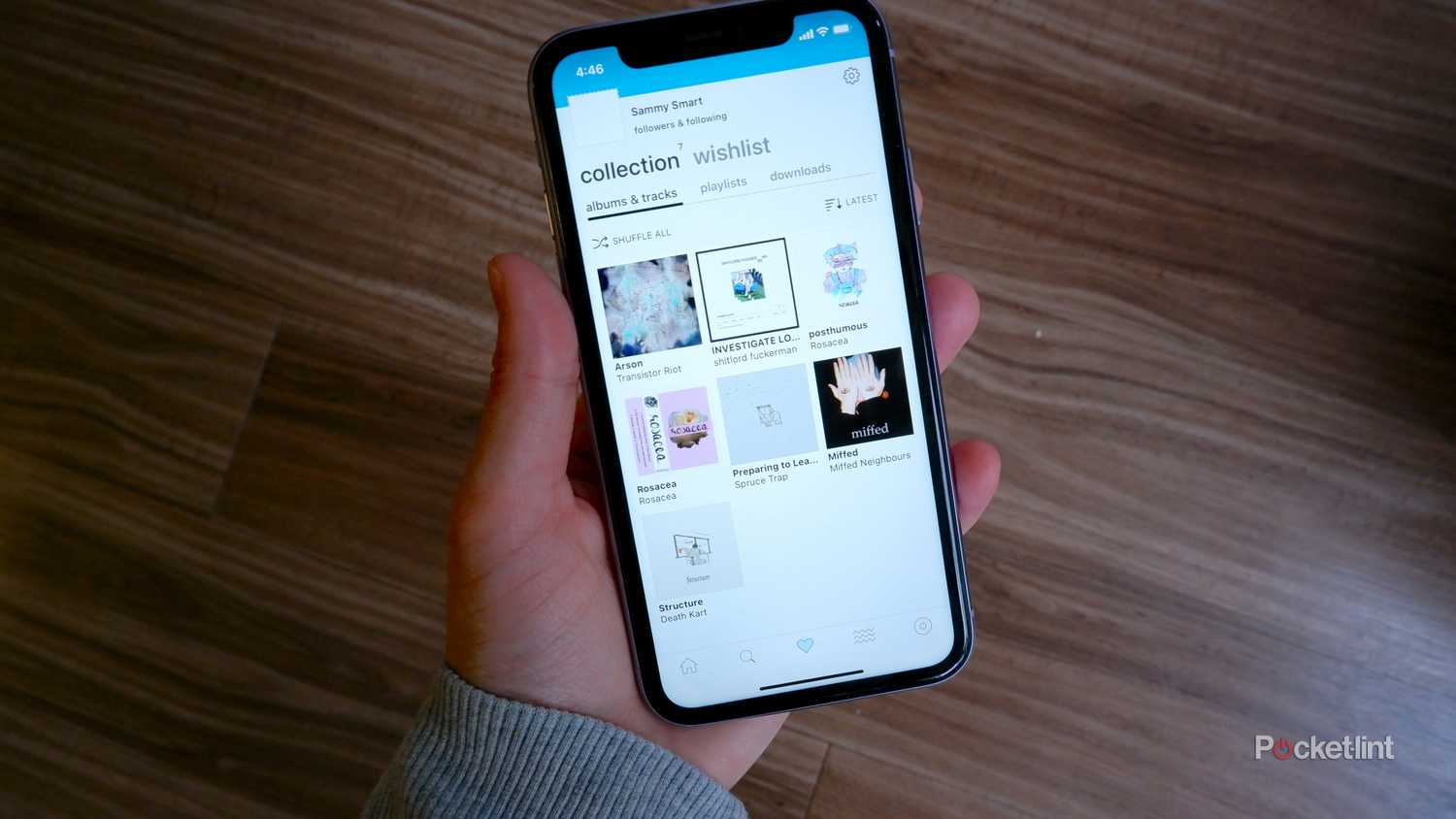 An iPhone with the Bandcamp app open showing a collection of purchased music
