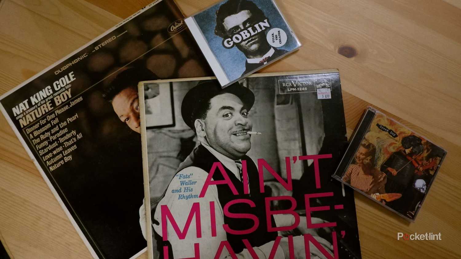 Two CDs and two vinyl records on a wooden table