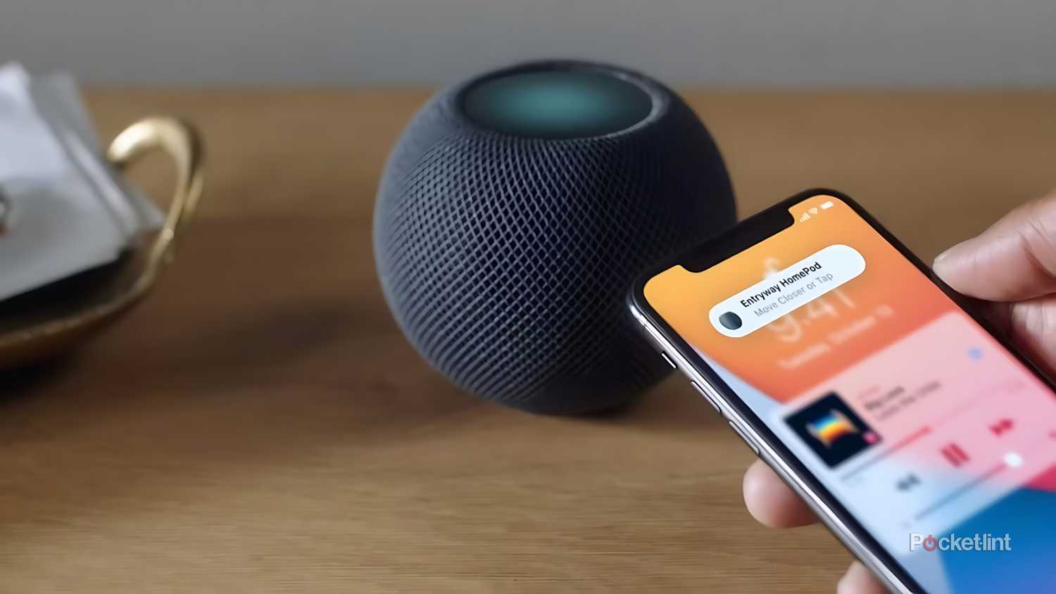 An iPhone hands off music to a HomePod mini.