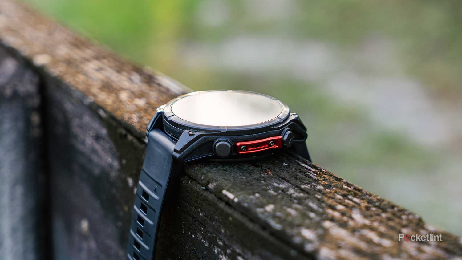 The Garmin Fenix 8 sits on an old fence. 