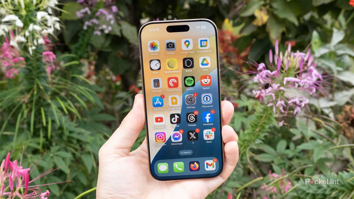 An iPhone 16 Pro in a garden.