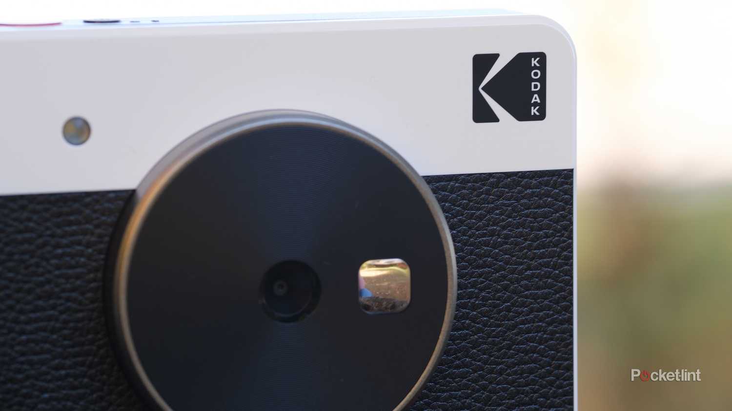 The Kodak Mini Shot 3 Retro sits on a stump outside