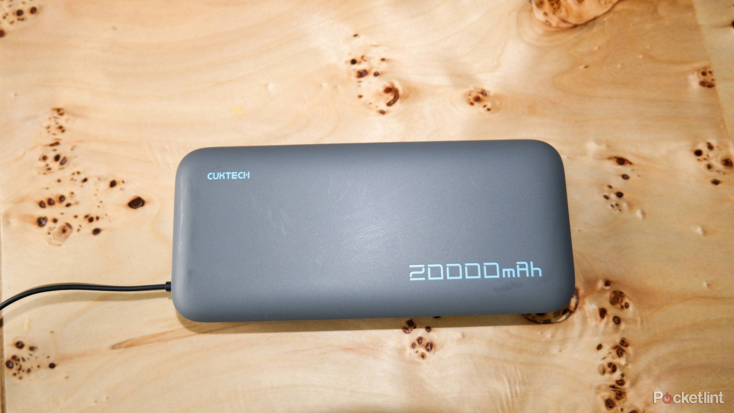 Cuktech's 20,000 mAh charger on a wooden surface. 