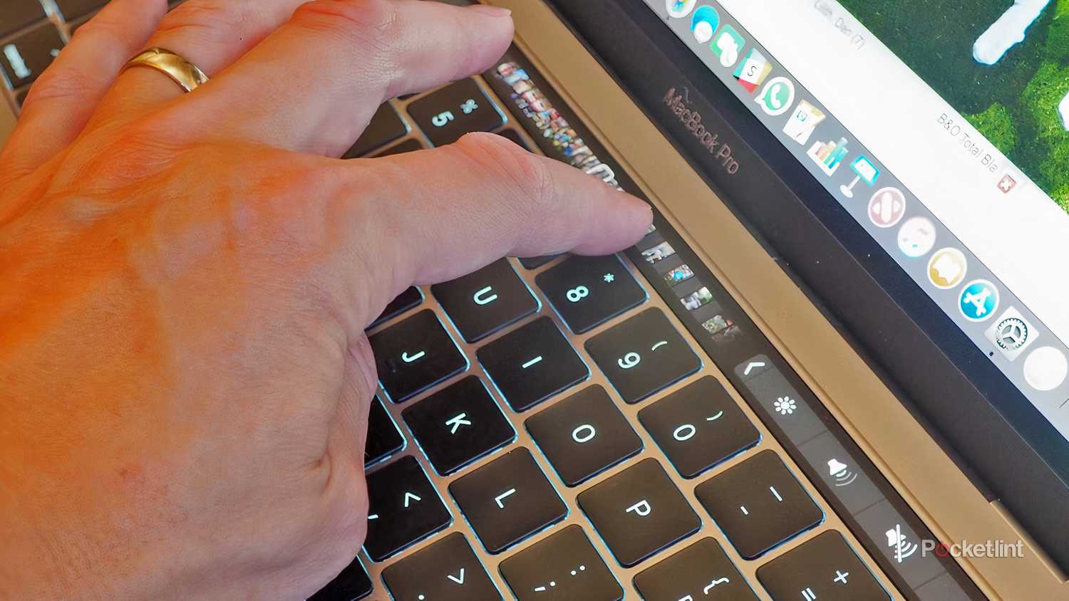 A finger swiping on the Touch Bar of a MacBook Pro.