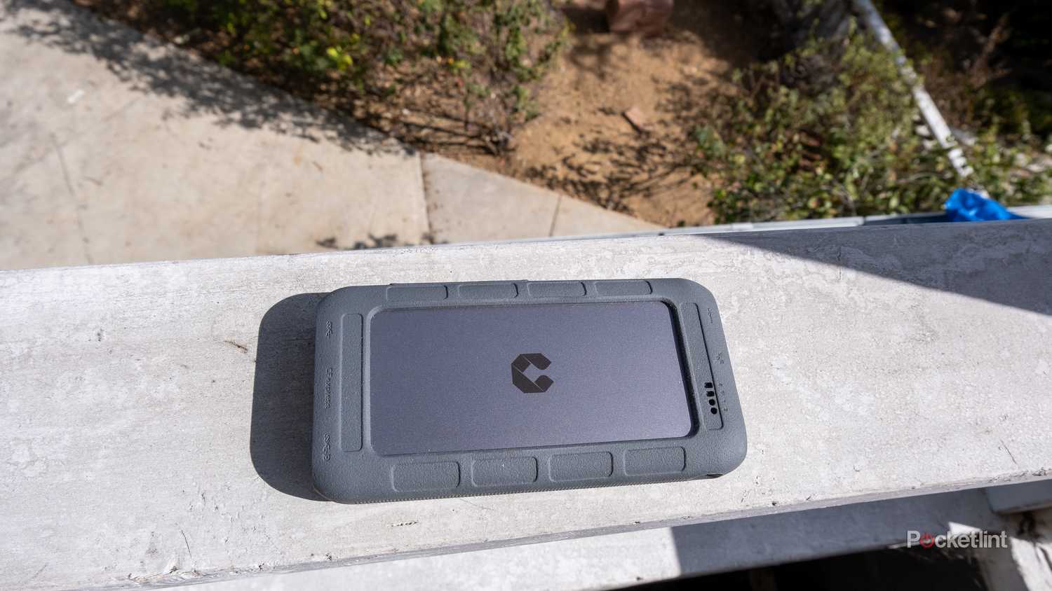 A photograph of the UnifyDrive UT2 Portable NAS outdoors on a balcony.