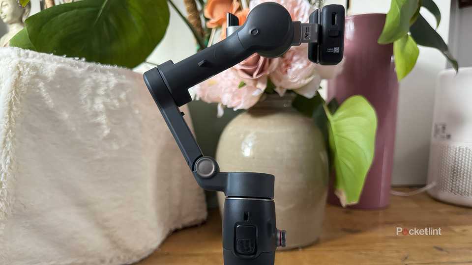 The DJI Osmo 7P gimbal from the other side in front of a vase. 