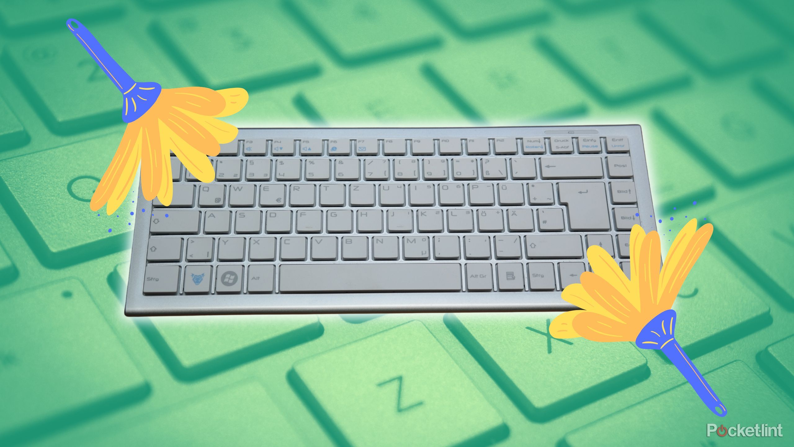 Two feather dusters cleaning a keyboard. 