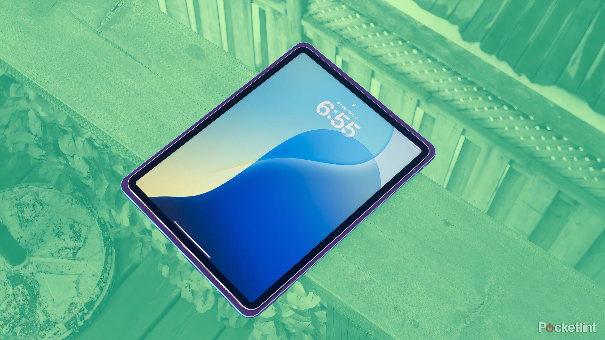 An iPad Air sitting on a deck over a green background.