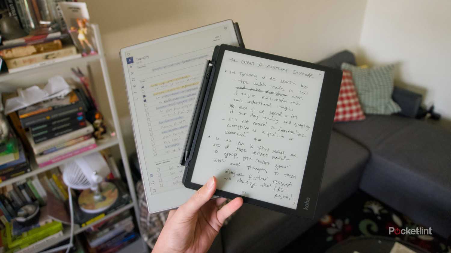 A hand holding a Kobo Elipsa 2E on top of a reMarkable Paper Pro.