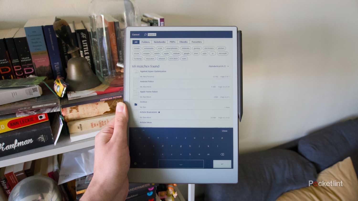 A hand holding a reMarkable Paper Pro open to its search screen.