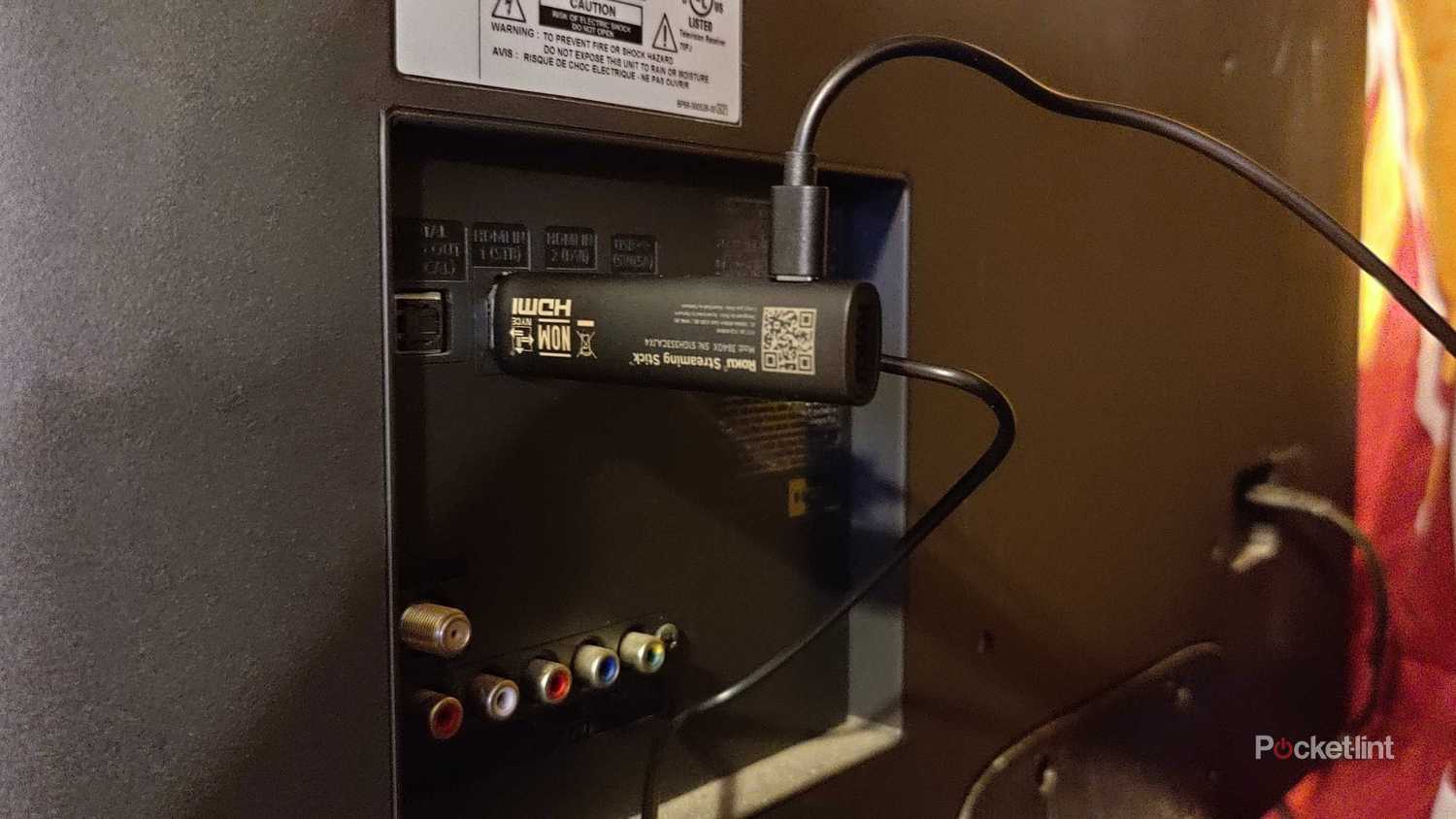 Roku USB TV stick plugged into a TV. 