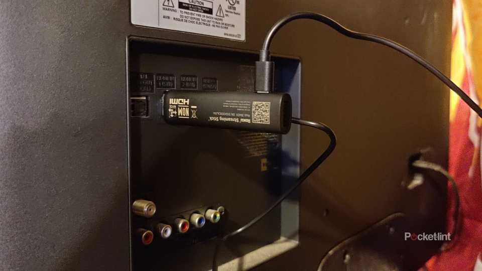 Roku USB TV stick plugged into a TV.