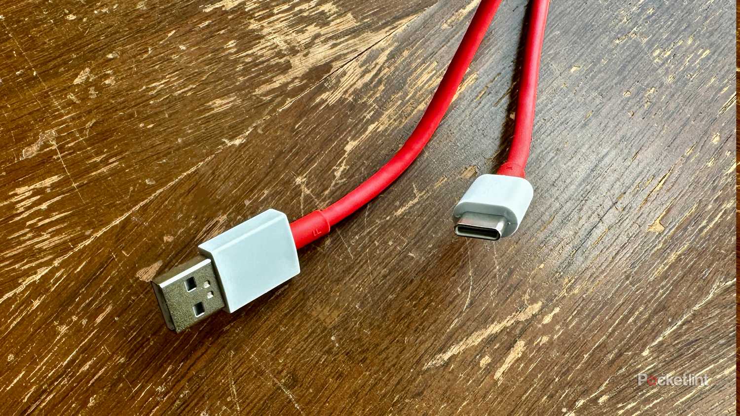 Red USB-A and USB-C cables on old cedar chest.