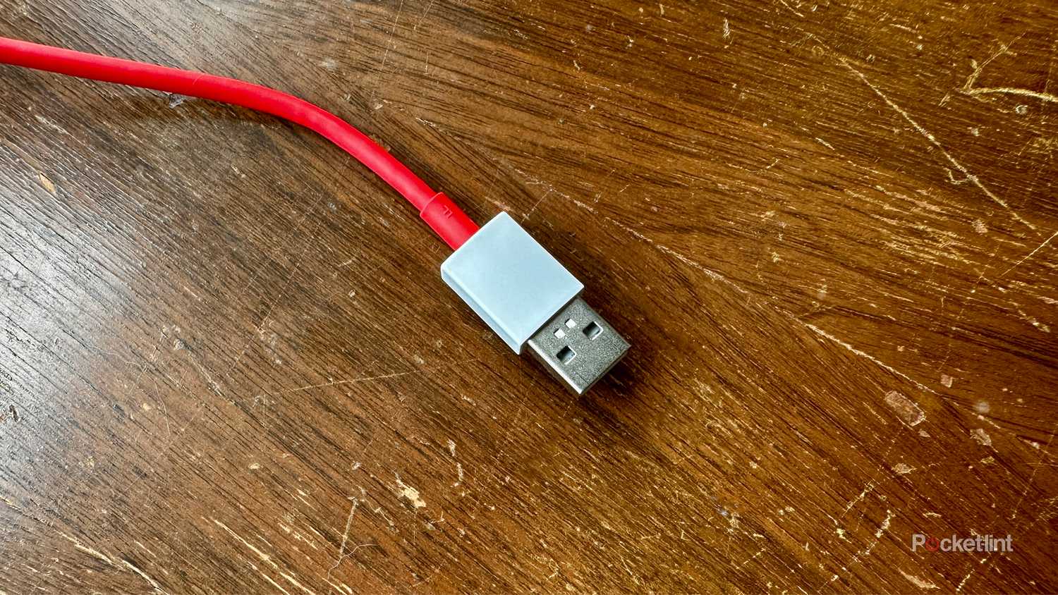 Red USB-A cable on old cedar chest.