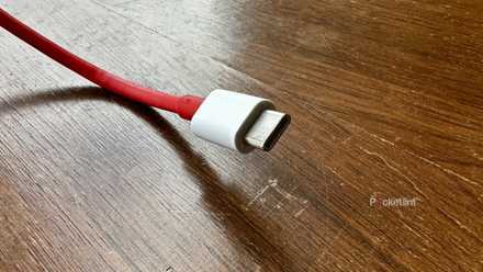 A red USB-C cable on an old cedar chest.