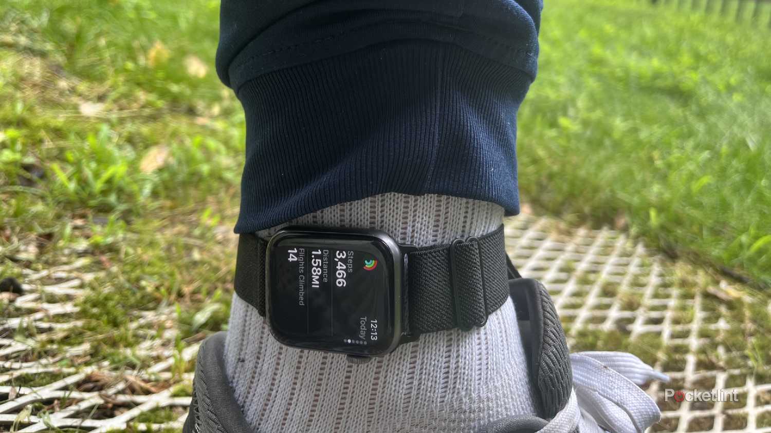 An Apple Watch on an ankle showing steps outside