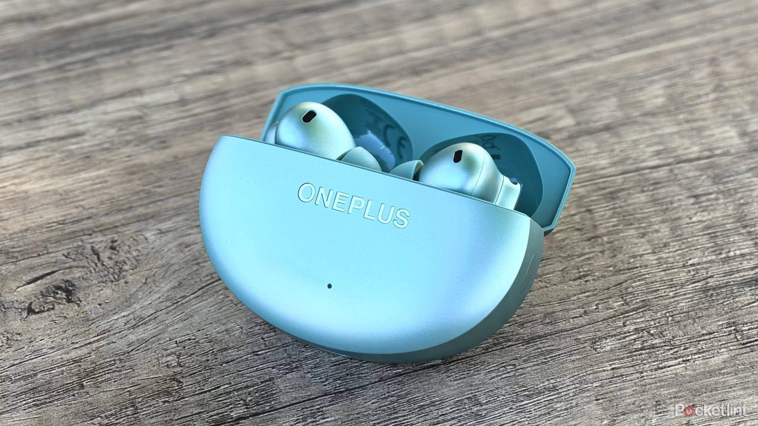 OnePlus Buds 4 on a table with case open.