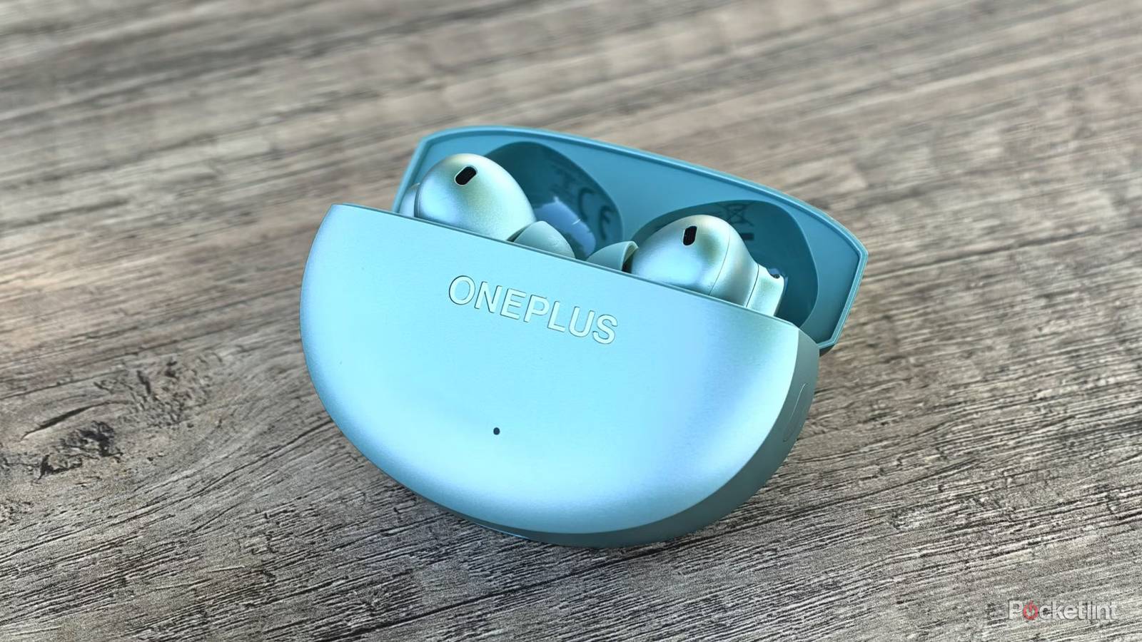 OnePlus Buds 4 on a table with case open.