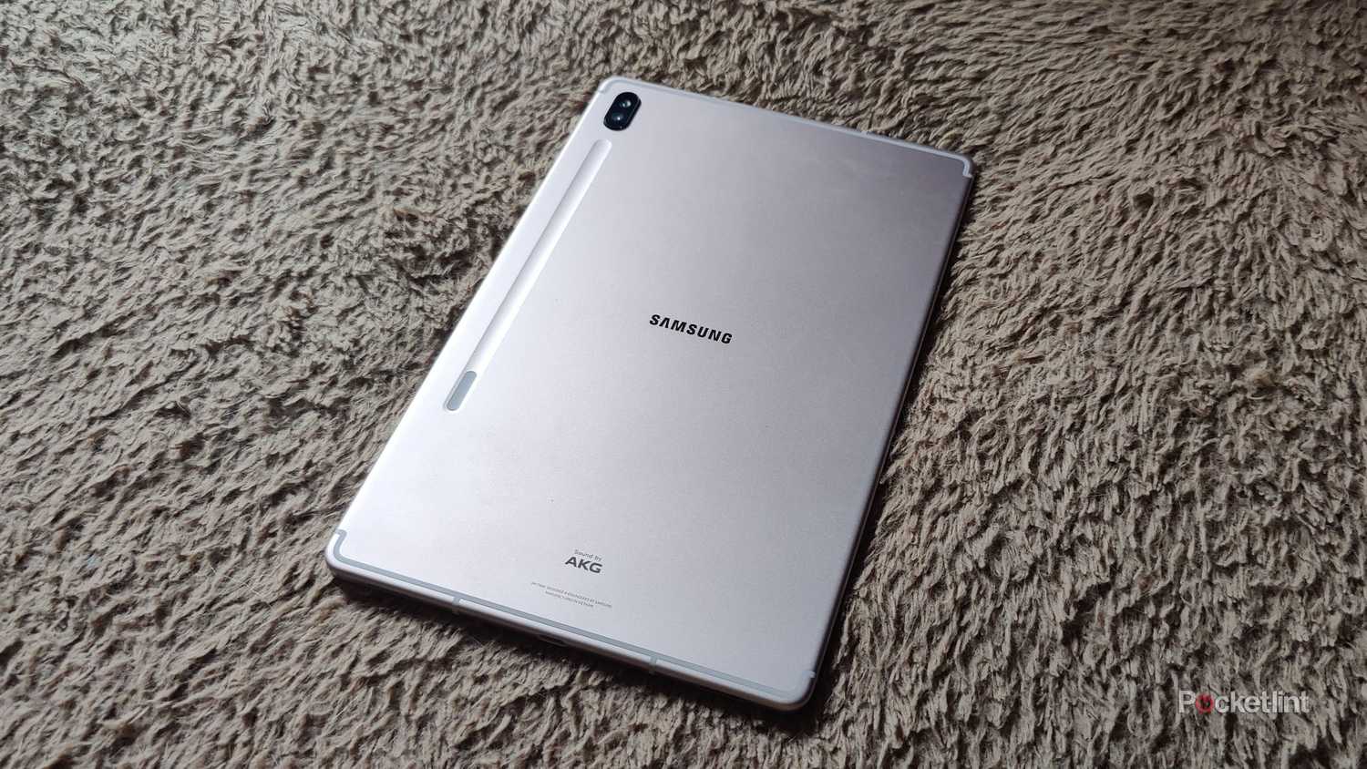 A Samsung Galaxy Tab S6 facedown on a carpet.