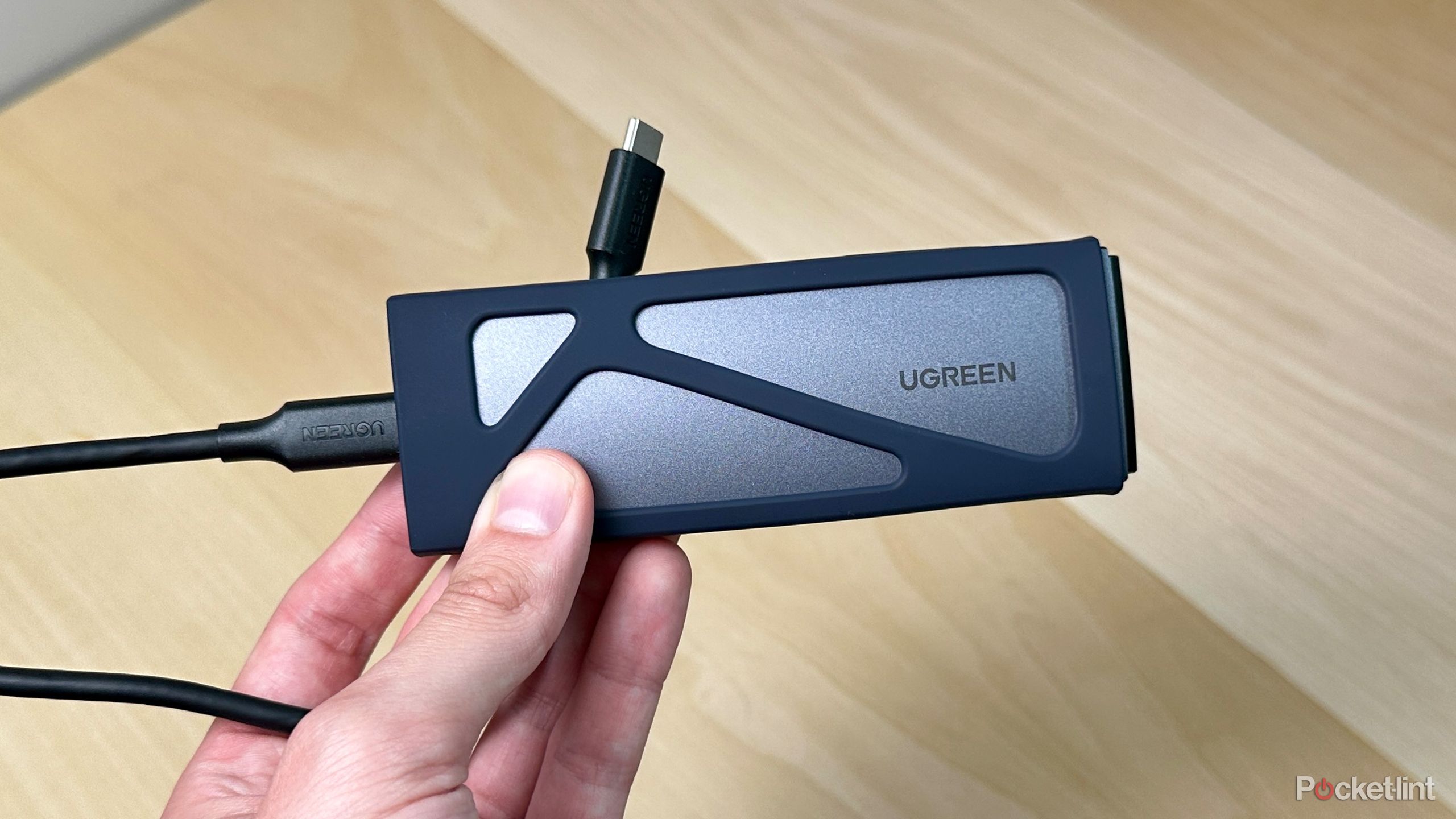 A UGREEN SSD enclosure in hand.