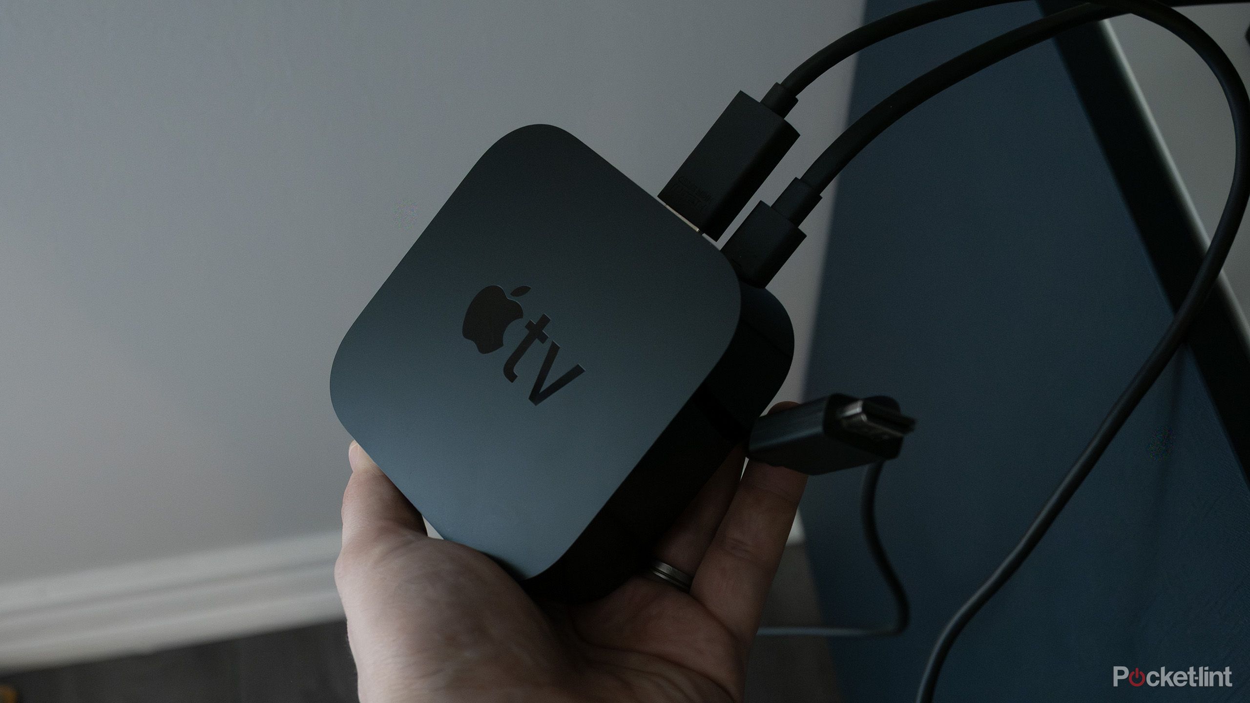 A hand holding an Apple TV 4K.