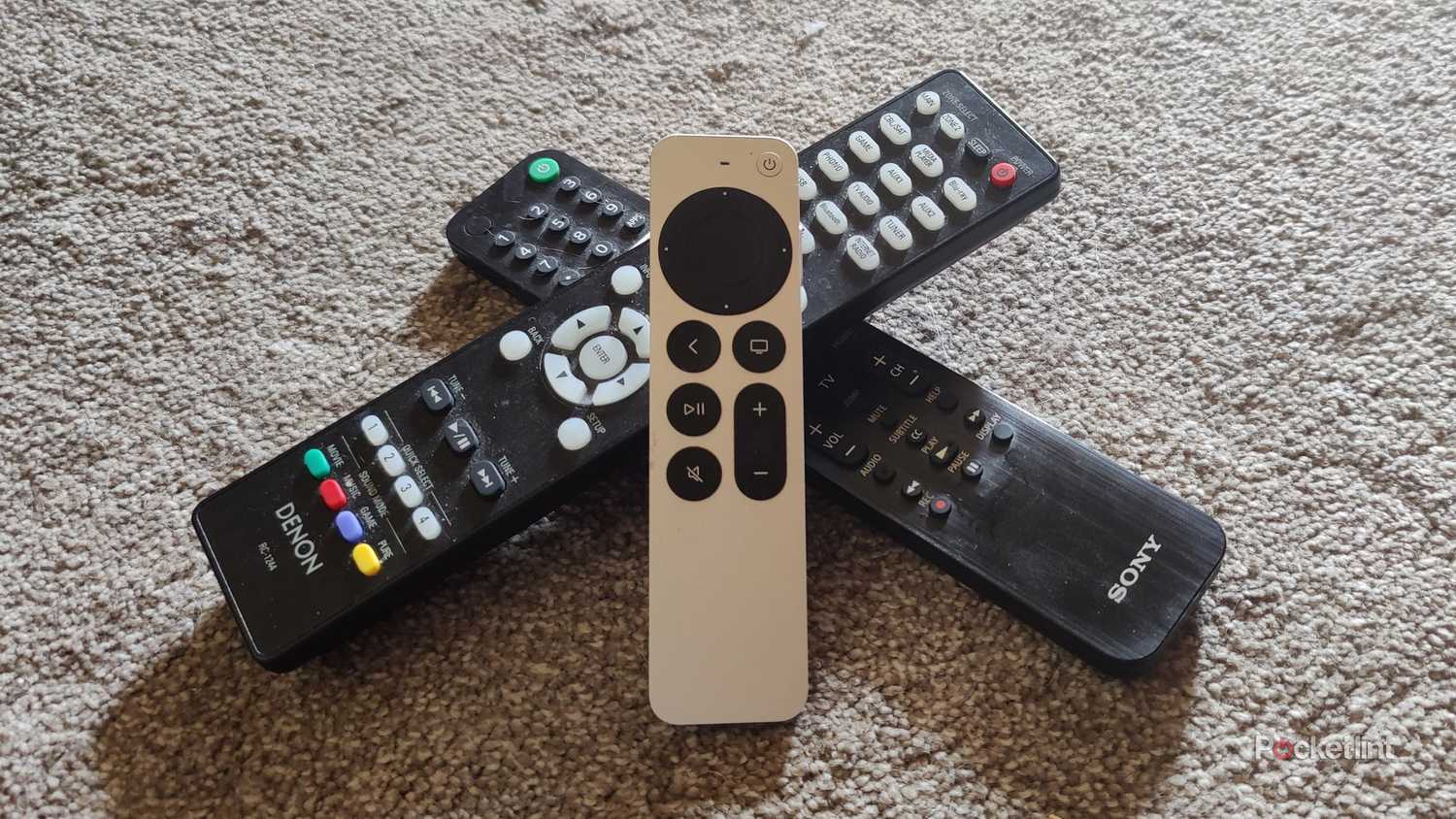 Apple TV 4K remote sitting on two remotes.