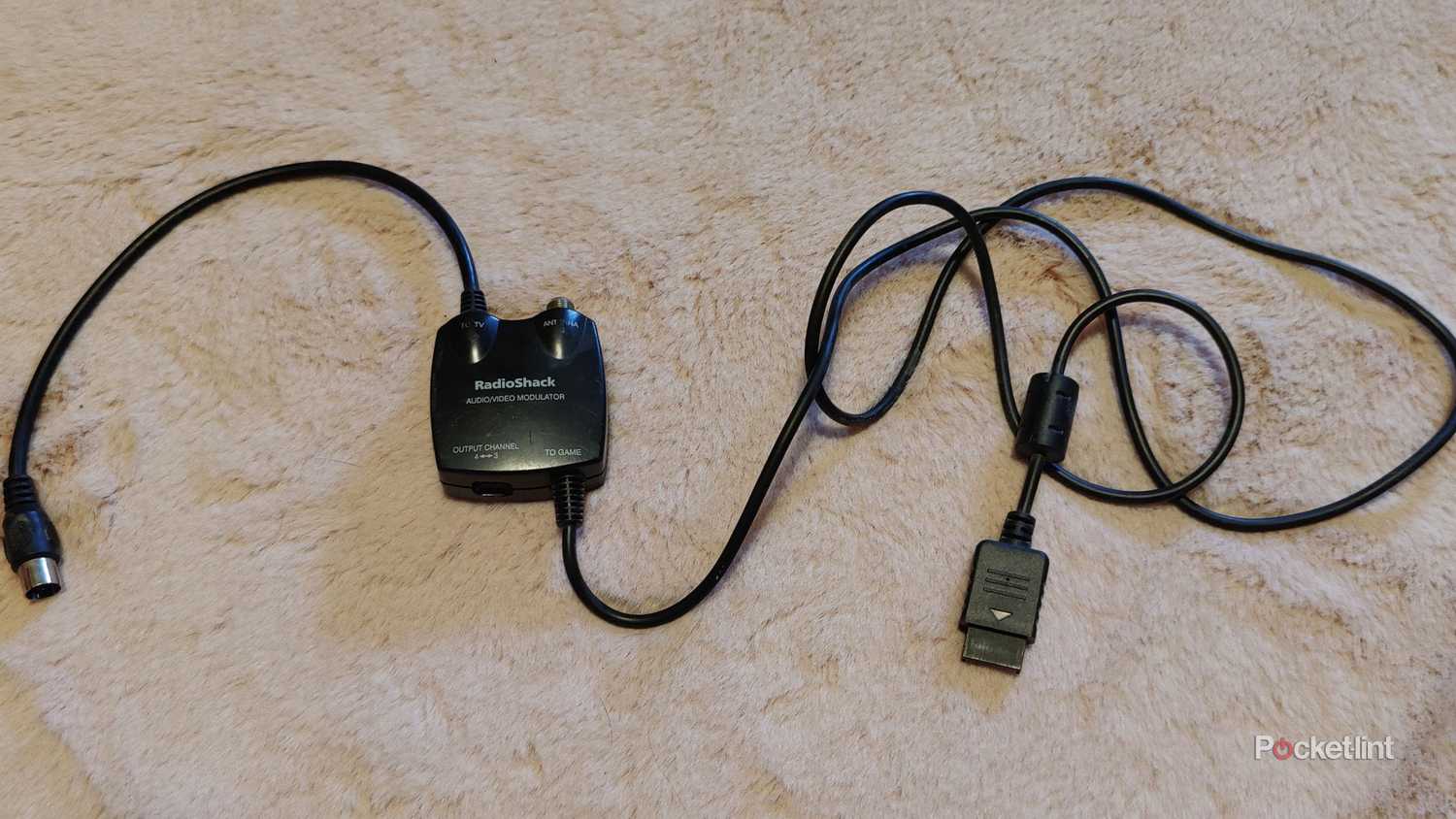 black radio shack a/v modulator on rug