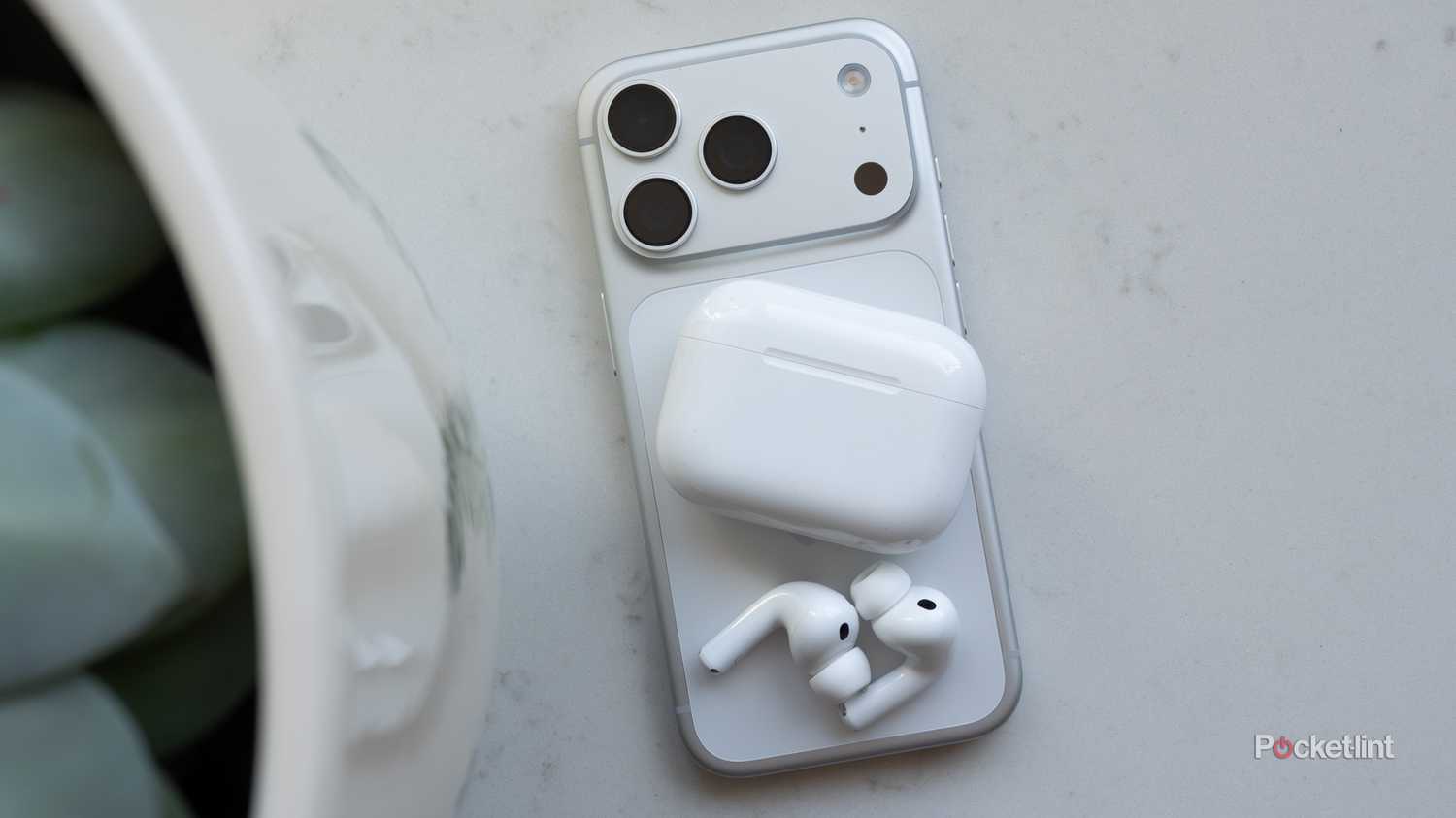 The AirPods Pro 3 sitting beside the iPhone 17 Pro 
