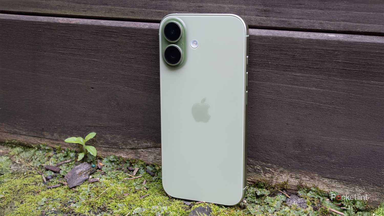An iPhone 17 against a fence.