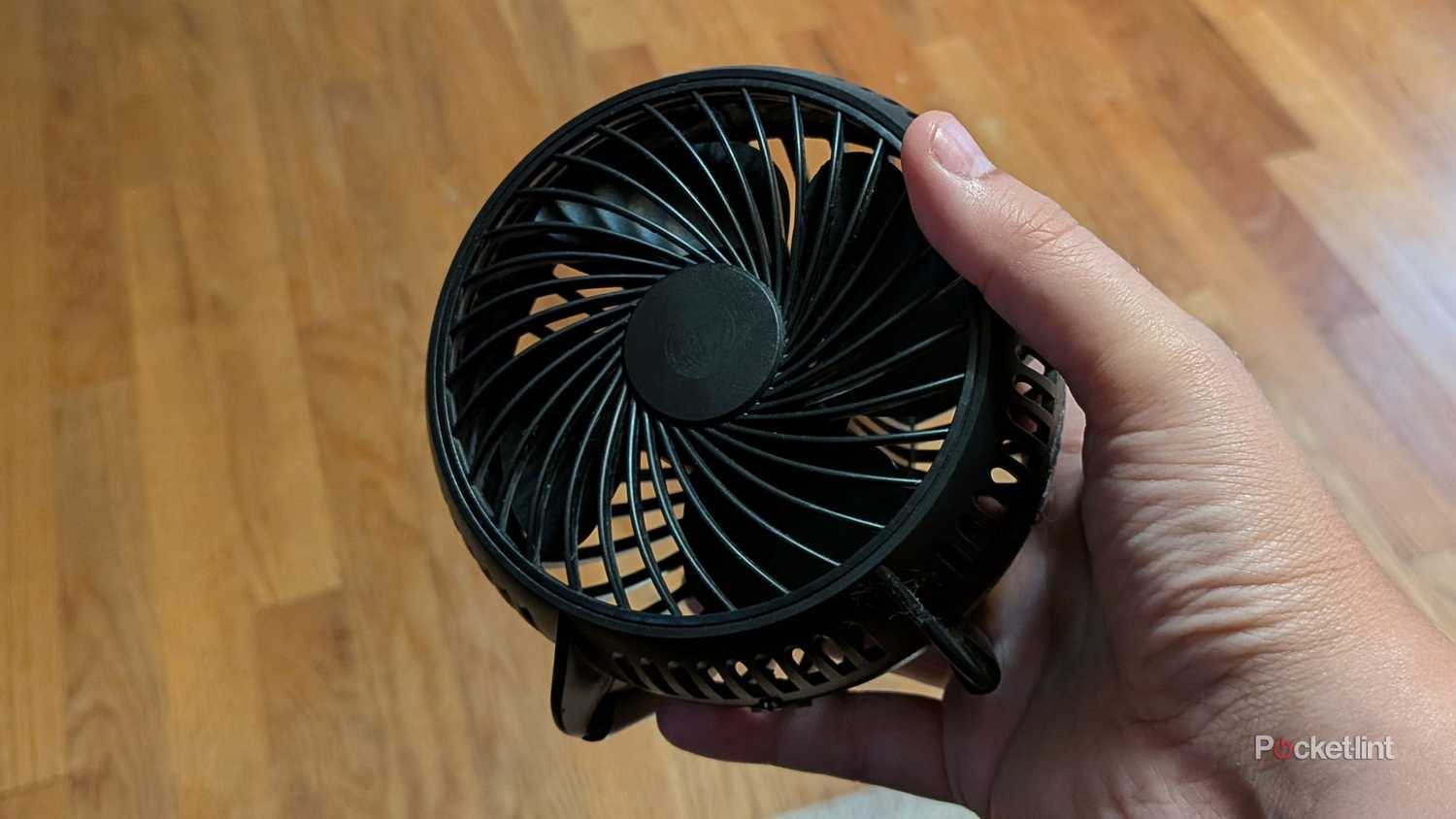 A person holding a USB fan.