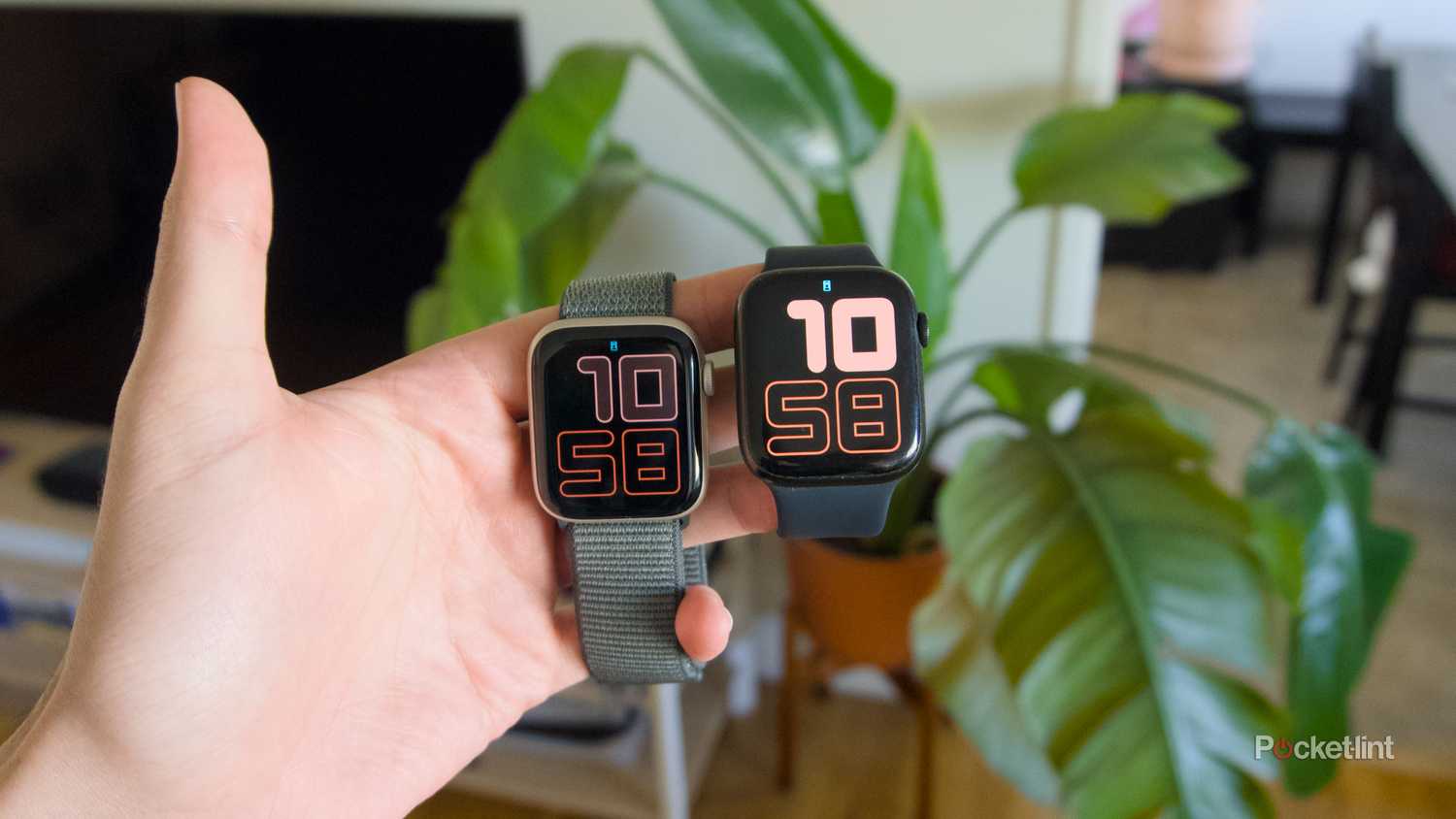 A hand holding an Apple Watch SE 3 and an Apple Watch Series 7.