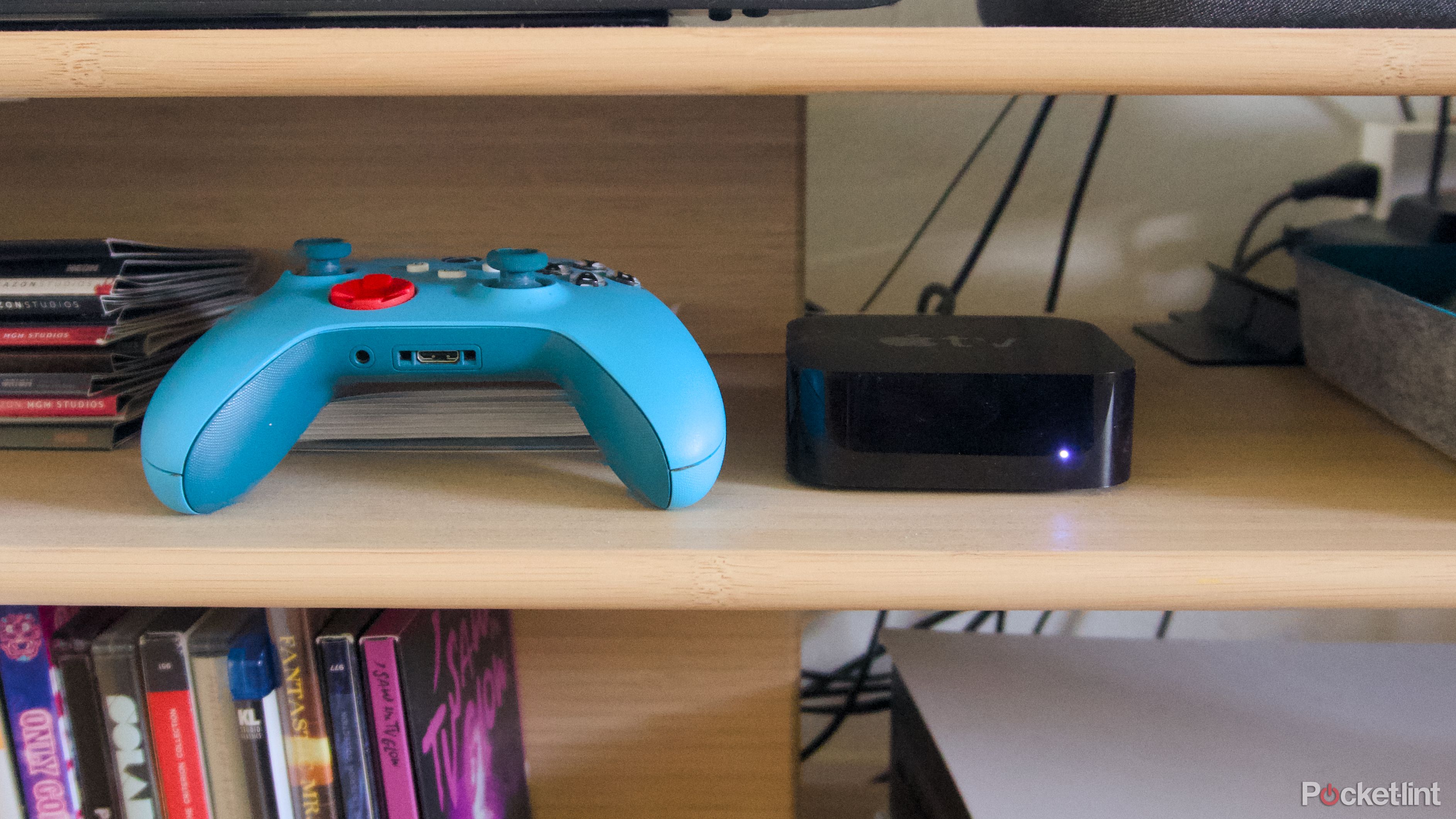 An Xbox game controller next to an Apple TV 4K.