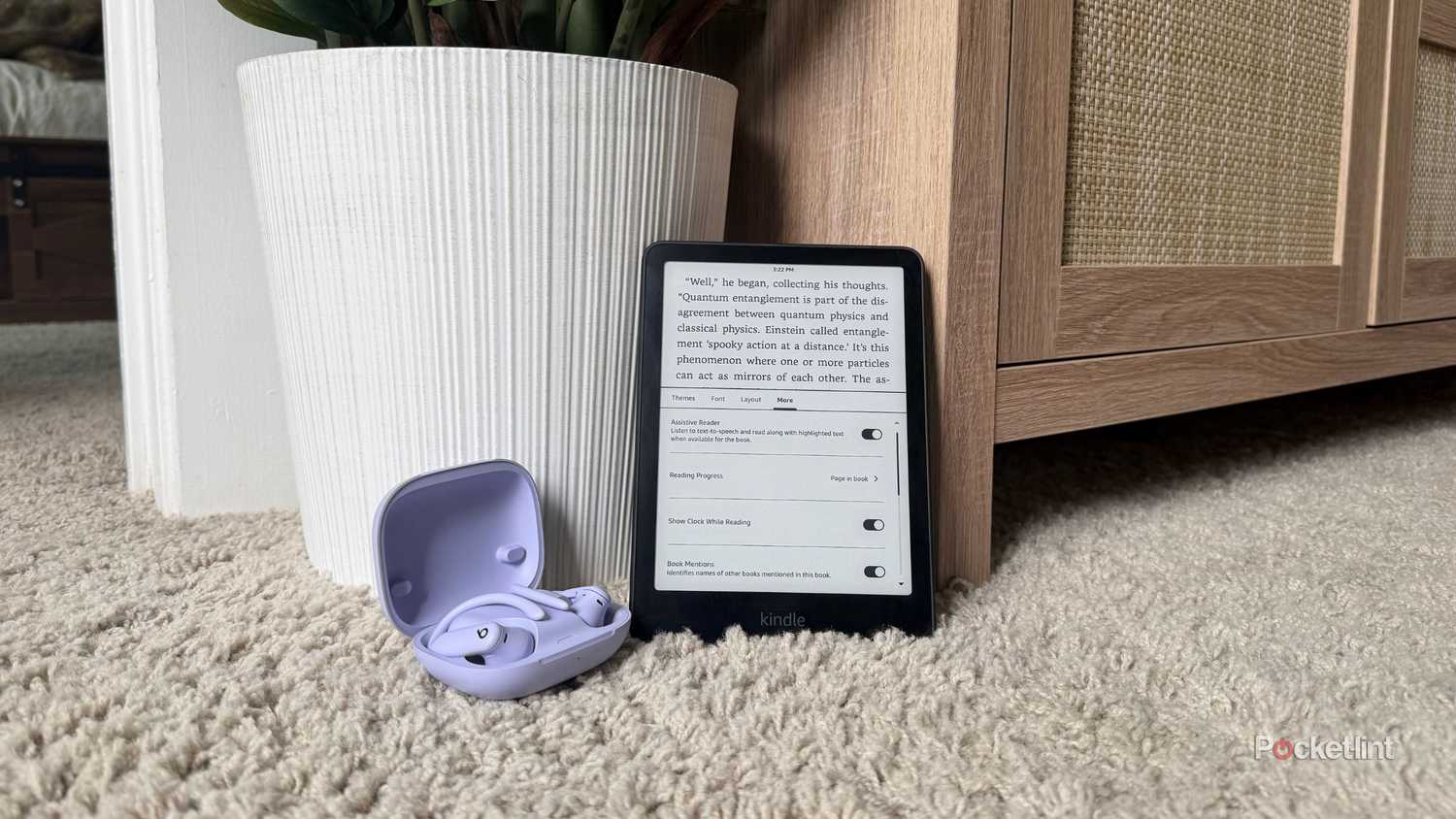 Bluetooth headphones beside a Kindle Paperwhite. 