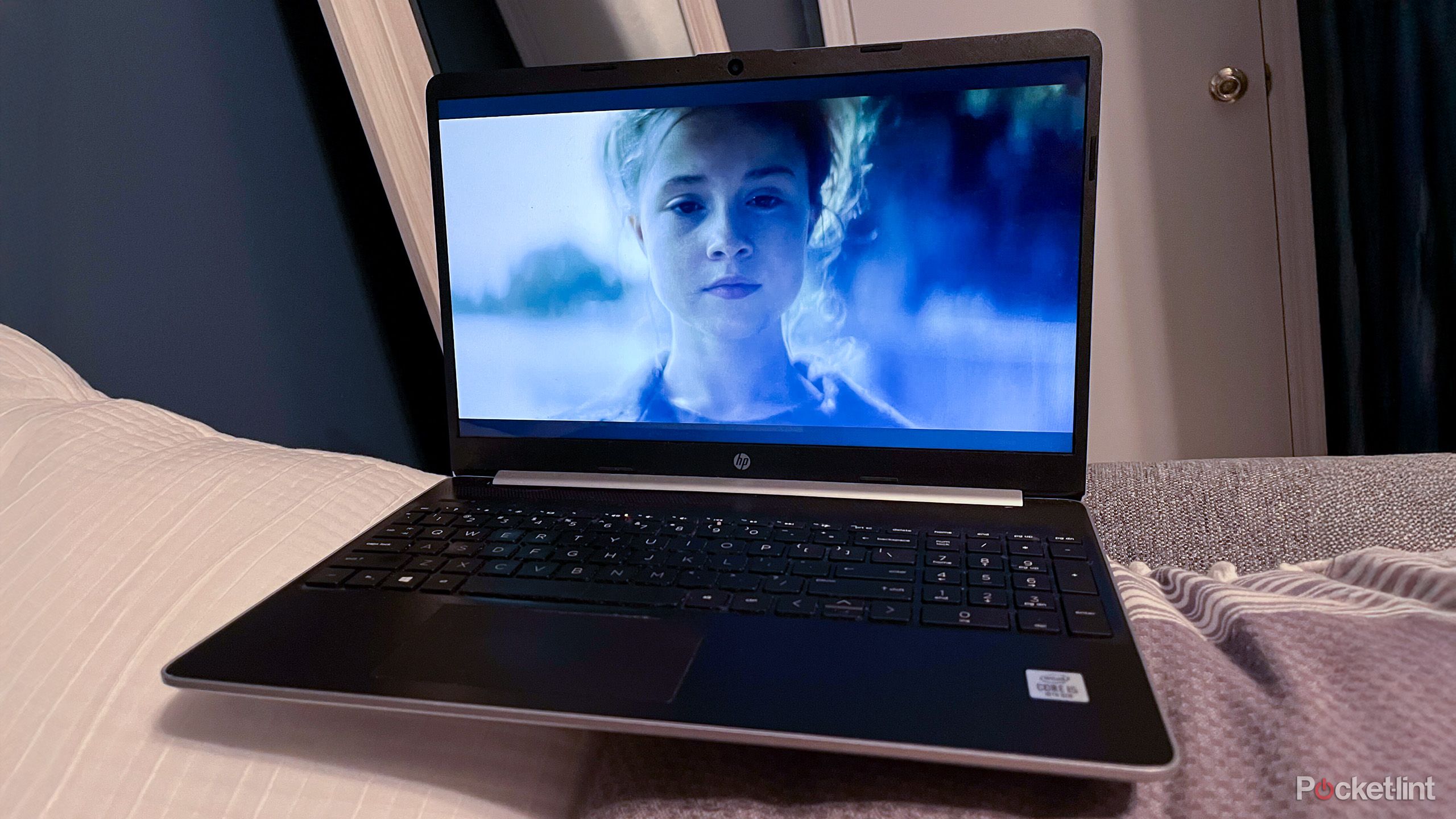 An older laptop sitting on a bed 