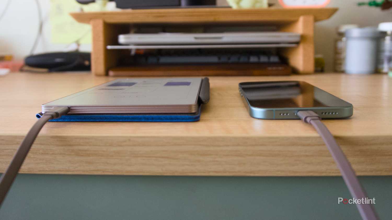 A reMarkable Paper Pro Move connected to a USB-C cable that's connected to an iPhone 16.