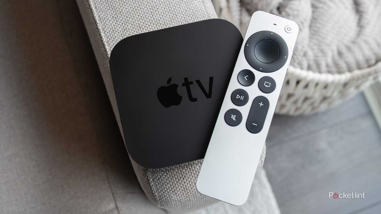 The Apple TV 4K (2021) and the Siri Remote sitting on a couch arm