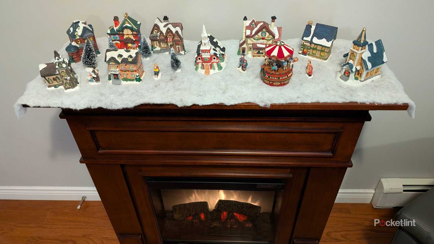 یک شومینه برقی با دهکده کریسمس در بالای آن.