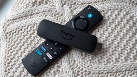 Fire TV Stick and Fire TV remote on knit pillow.