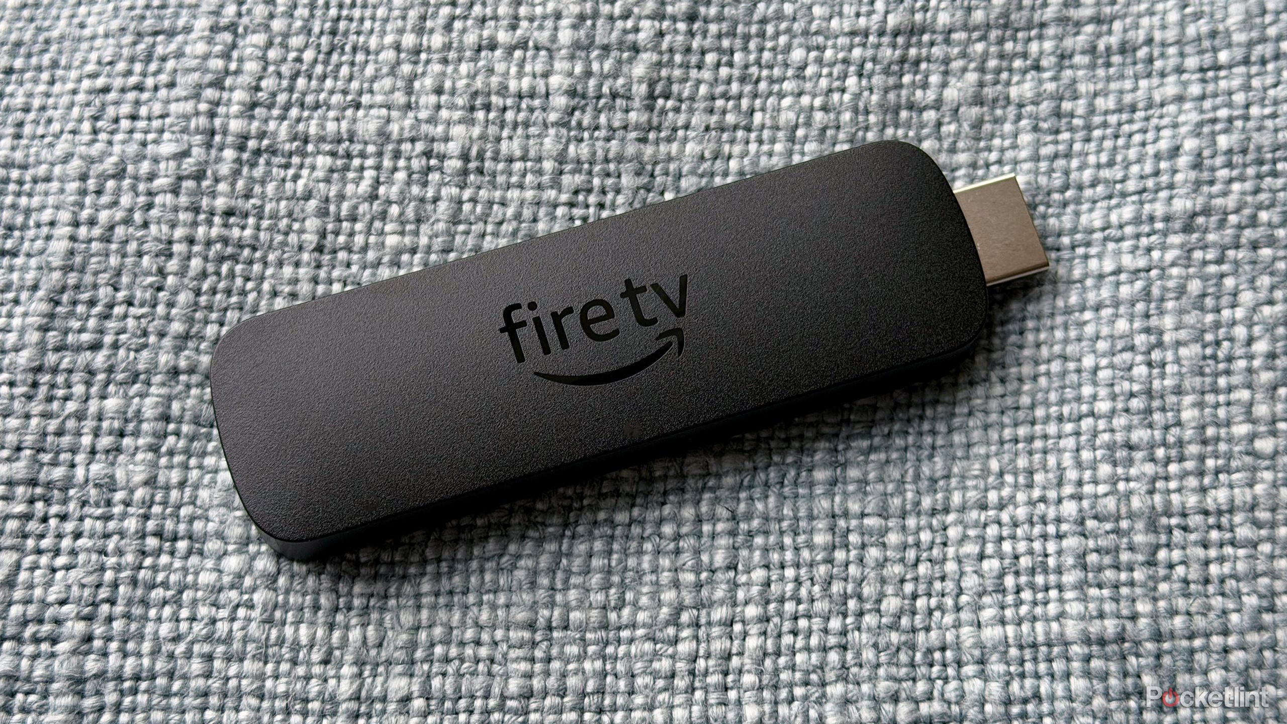 Fire TV Stick on blue pillow.