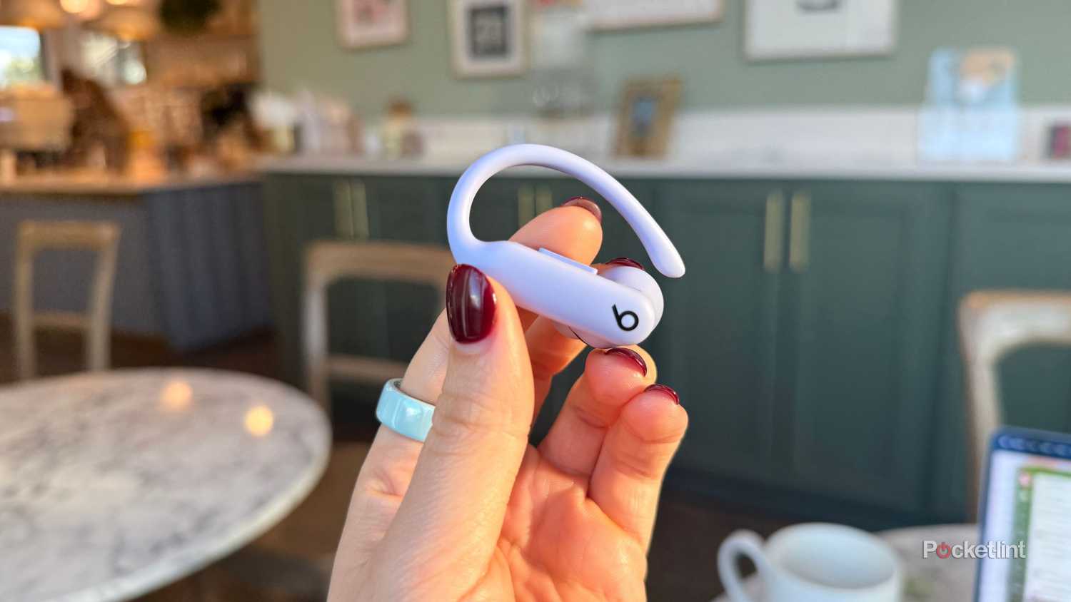 A purple ear bud in hand.