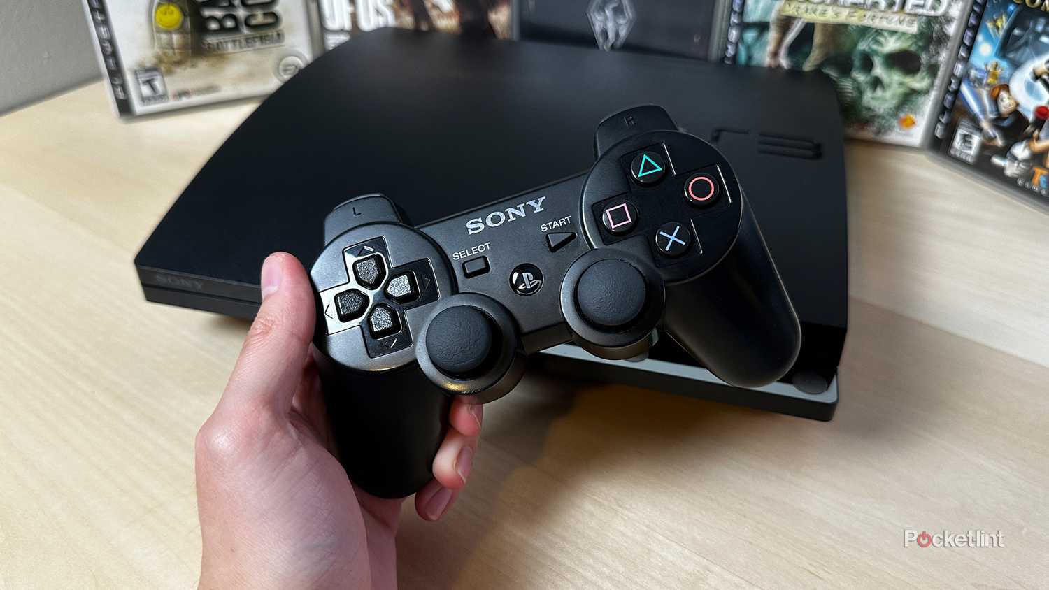 PS3 controller in front of PS3 console and games.