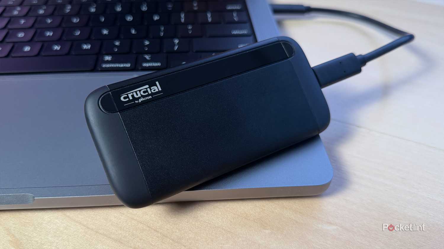 An external Crucial SSD plugged into a MacBook.