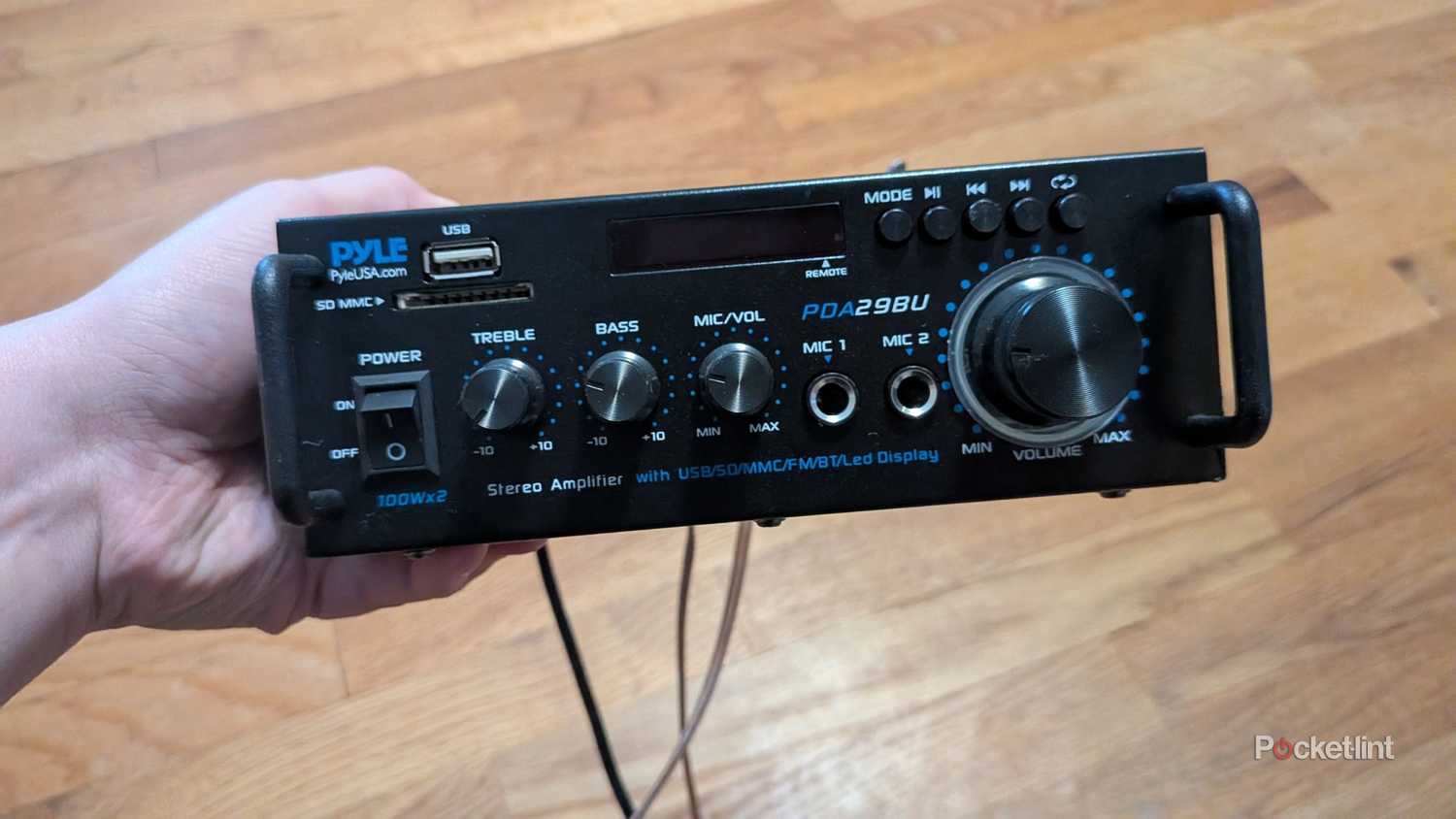 A person holding a Pyle audio receiver.