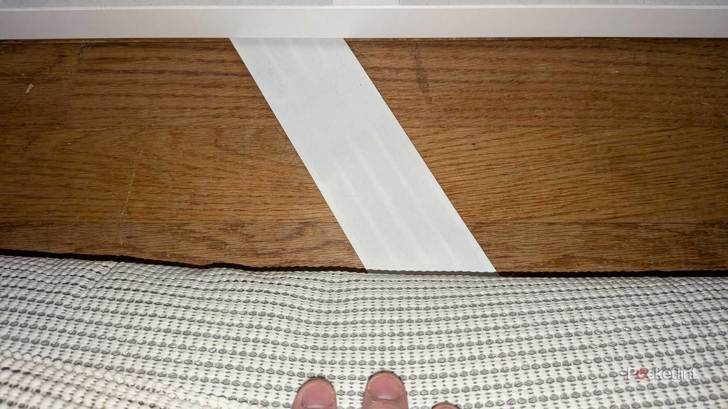 A ghost wire running underneath a rug.